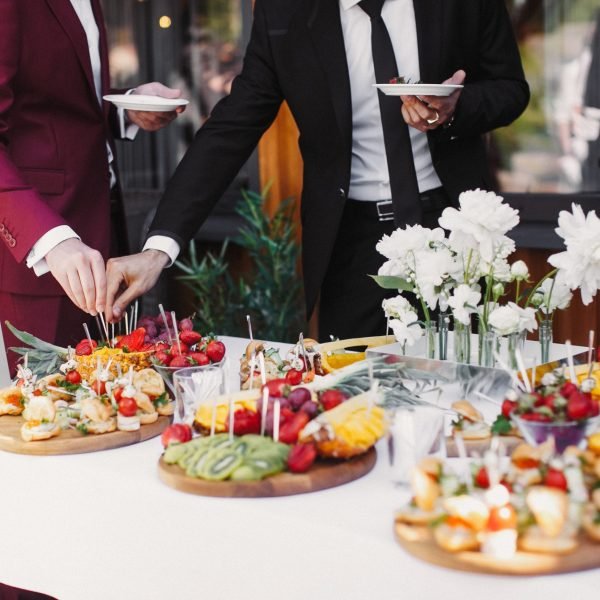Close up of people serving themselves with fruits in buffet of restaurant